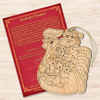 a handmade ornament and a certificate of authenticity, both placed on a wooden surface.