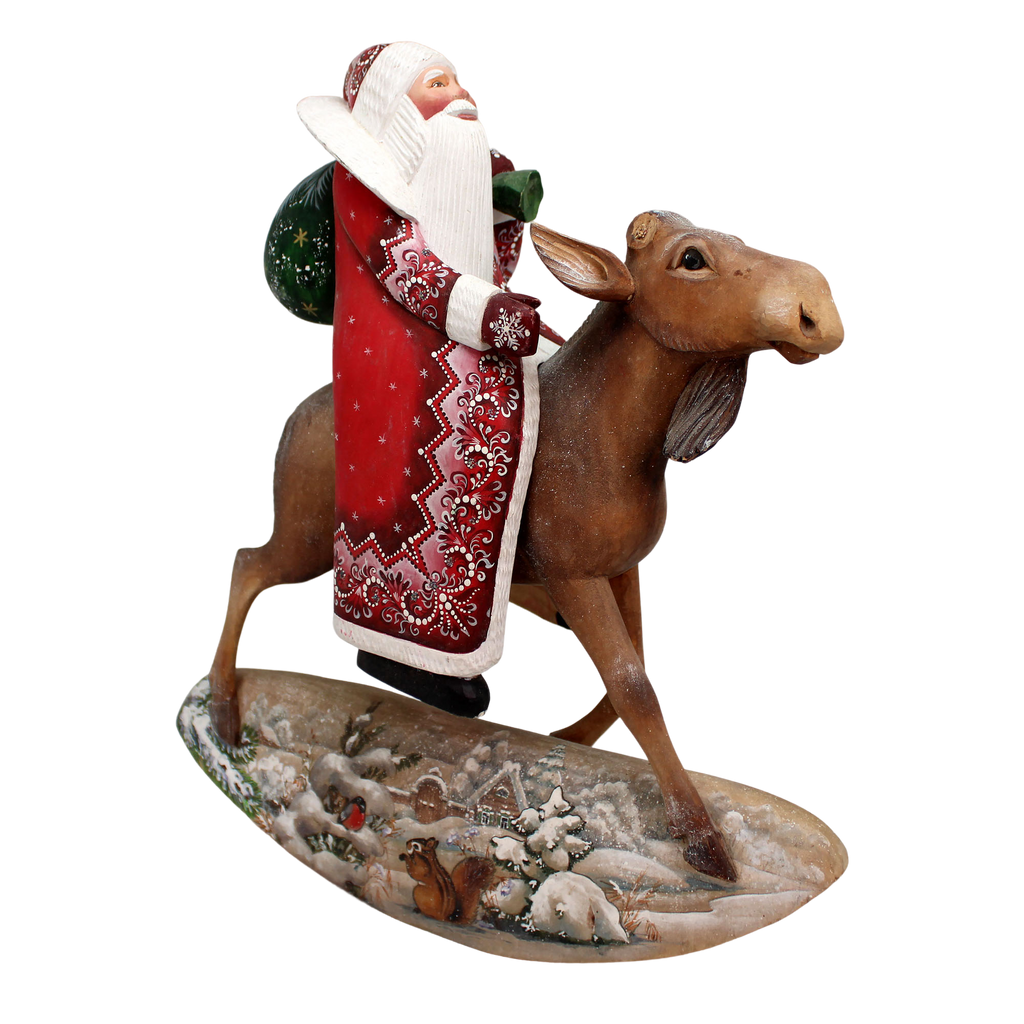 A figurine of Santa Claus riding a moose on a snowy landscape.