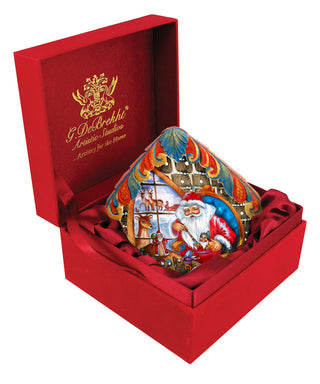 A red box containing a colorful, hand-painted ceramic piece depicting a Christmas scene with Santa Claus and other festive characters.
