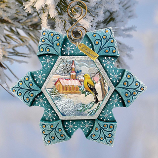 A decorative ornament featuring a yellow bird perched on a branch, with a snowy winter landscape in the background. The ornament has a blue and white color scheme and is hanging from a tree branch.
