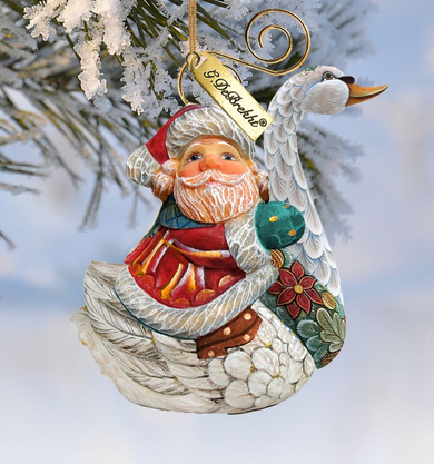 A decorative ornament featuring a Santa Claus figure with a swan-like design, hanging on a tree branch.