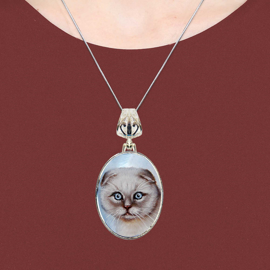 A silver necklace with a pendant featuring a close-up image of a cat's face.