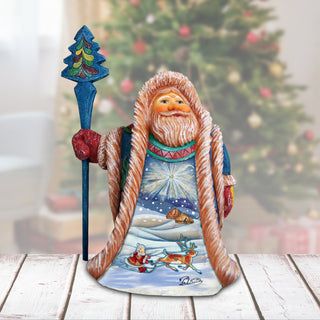 A colorful figurine of Santa Claus holding a reindeer and a star, set against a blurred Christmas tree background.