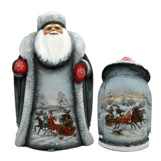 a large statue of Santa Claus and a smaller statue of a horse-drawn sleigh. Both statues are decorated with winter scenes and red snowflakes.
