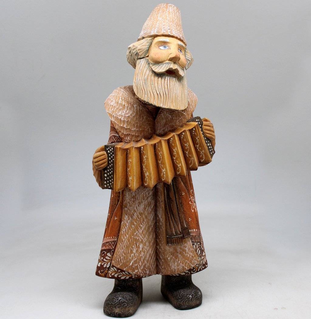 A wooden figurine of a bearded man playing an accordion.