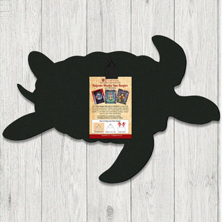 Back of handcrafted coastal wooden door hanger shaped like a sea turtle, created by G. Debrekht Artistic Studio. Includes hanging hardware and instruction card for easy wall or door display. Made in the USA with UV-protected coating, part of the Keepsake Wooden Door Hangers collection, perfect for coastal wall decor or nautical gifts.