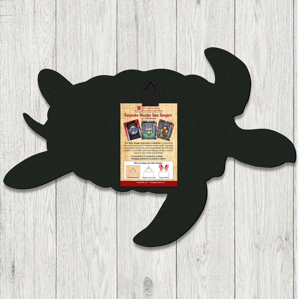 Back of handcrafted coastal wooden door hanger shaped like a sea turtle, created by GDebrekht Artistic Studio. Includes hanging hardware and instruction card for easy wall or door display. Made in the USA with UV-protected coating, part of the Keepsake Wooden Door Hangers collection, perfect for coastal wall decor or nautical gifts.