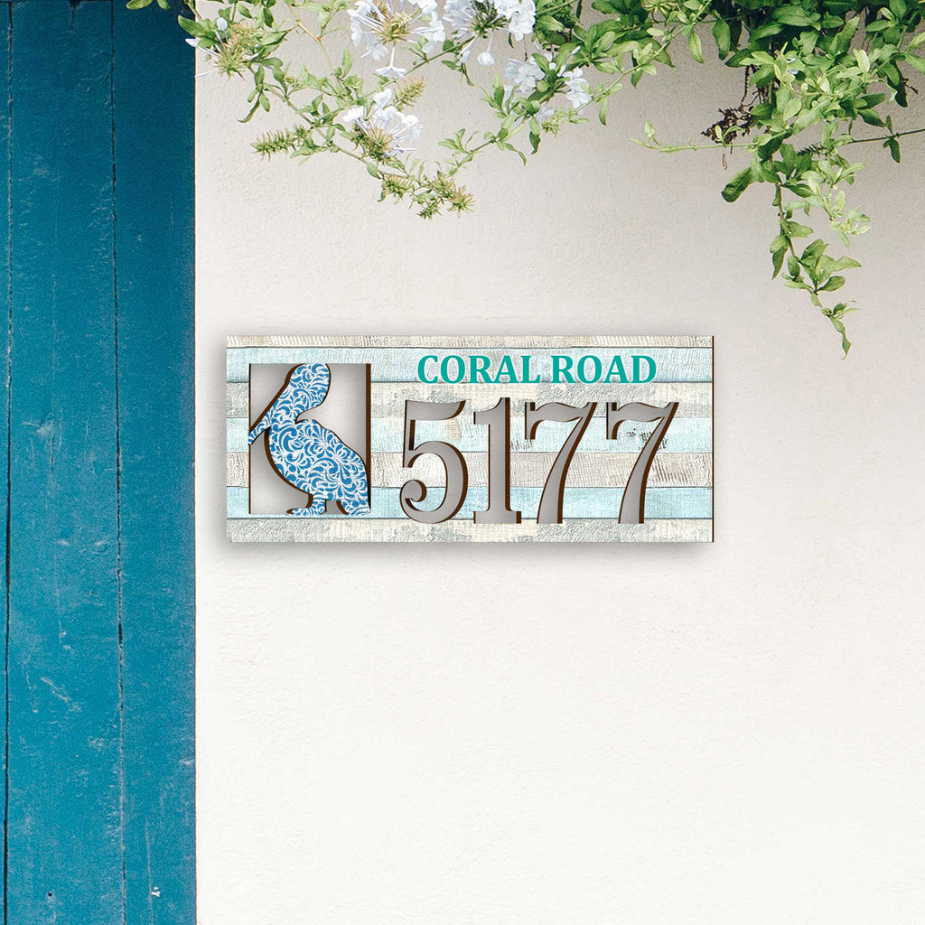 Coastal address plaque with blue pelican cutout, house number 5177, and customizable CORAL ROAD street name, handcrafted by GDebrekht Artistic Studio. Perfect for nautical house numbers, coastal door decoration, beach house decor, and outdoor holiday decorations.