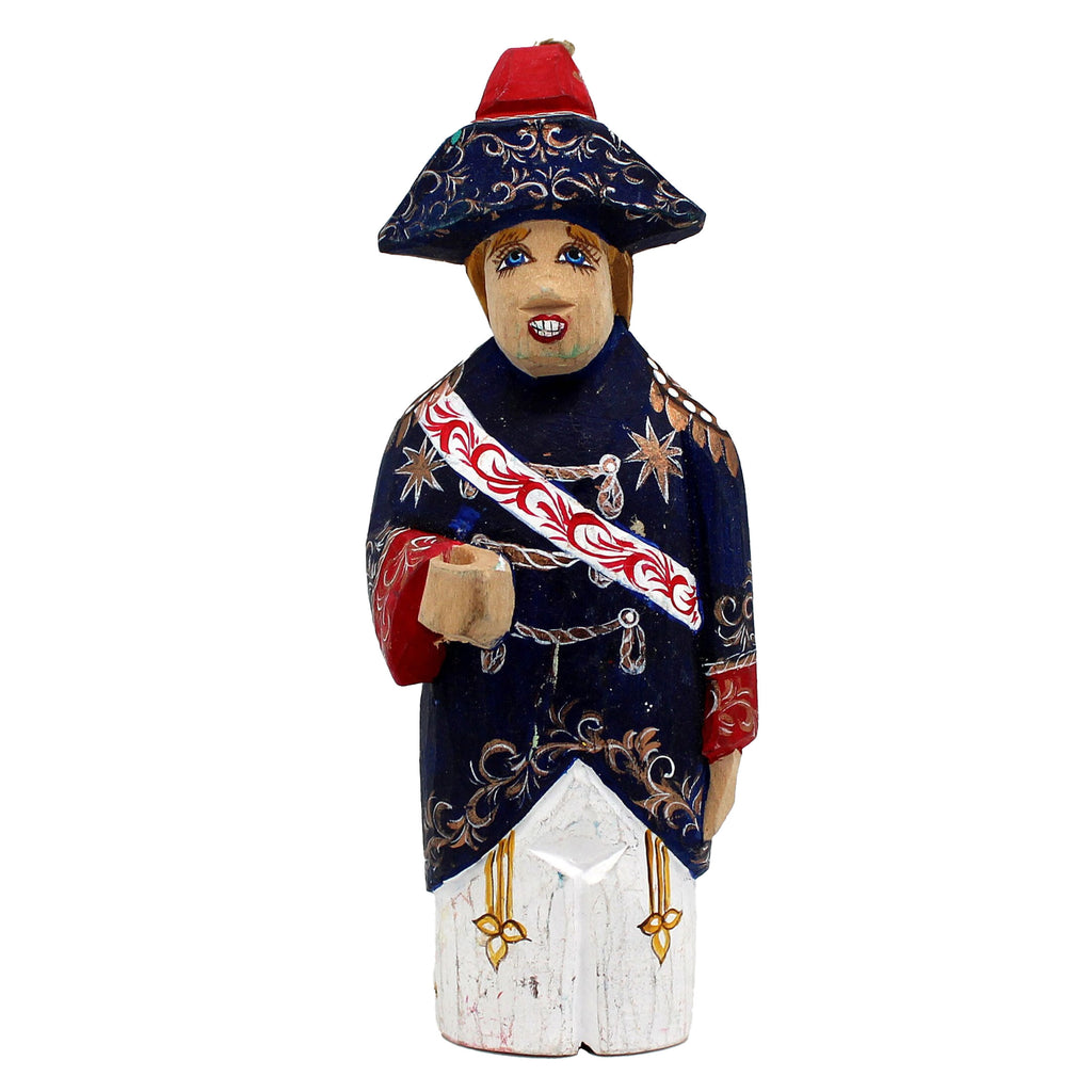 A wooden figurine of a person wearing a blue and red outfit with a red hat, standing against a white background.