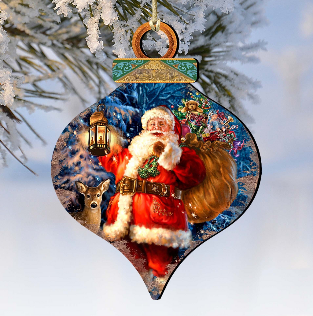 A Christmas ornament featuring a Santa Claus figure holding a lantern and a bag of presents, with a deer in the background.