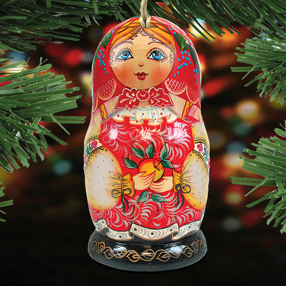 A colorful, intricately painted wooden doll ornament is displayed against a blurred background, possibly a Christmas tree.