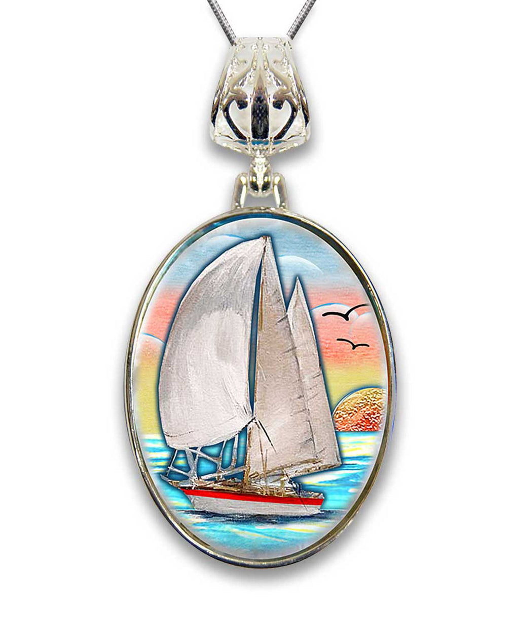 A pendant featuring a sailboat on the water with a sunset in the background.