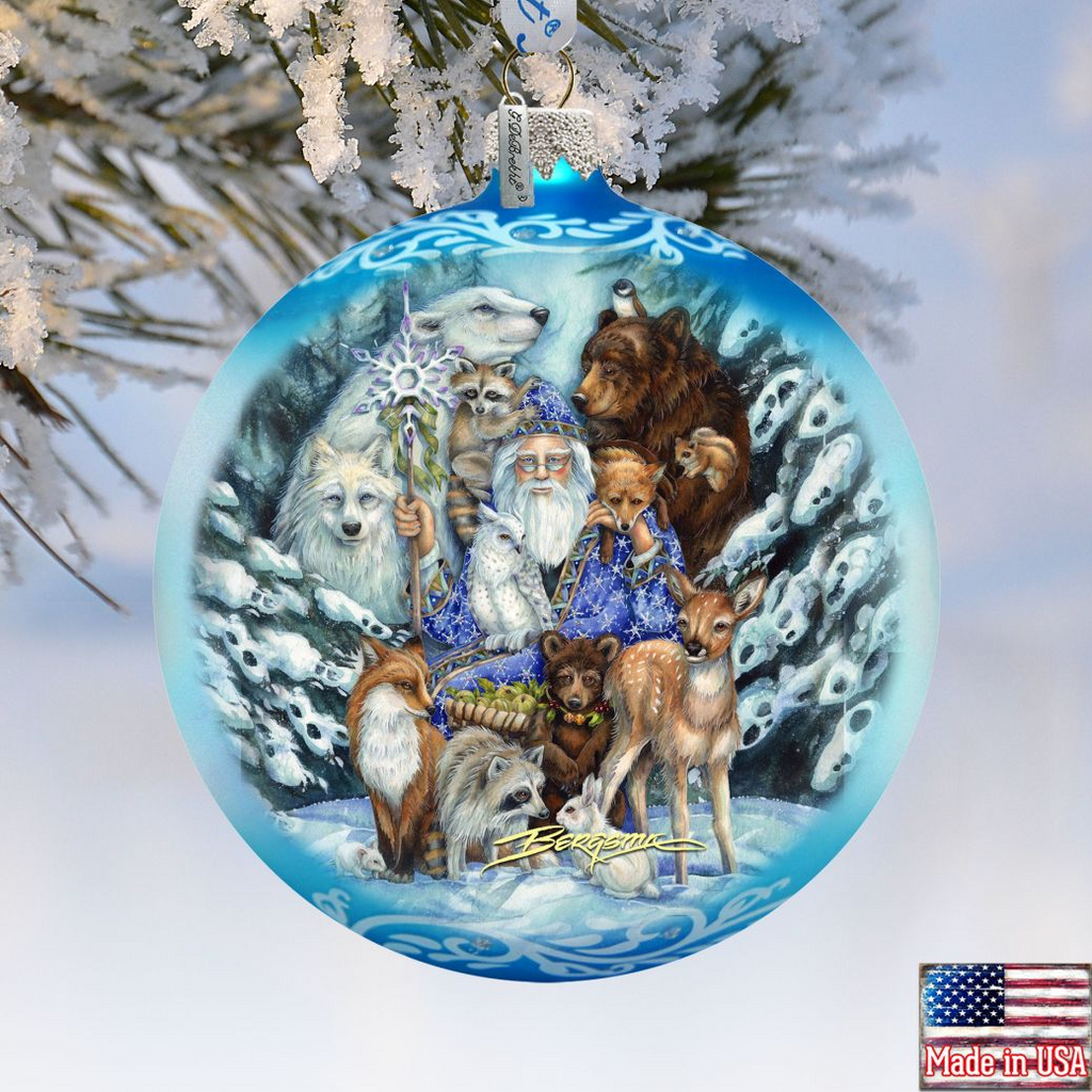 A blue Christmas ornament featuring a painting of a wizard surrounded by various animals, including a bear, deer, and fox, set against a snowy background.