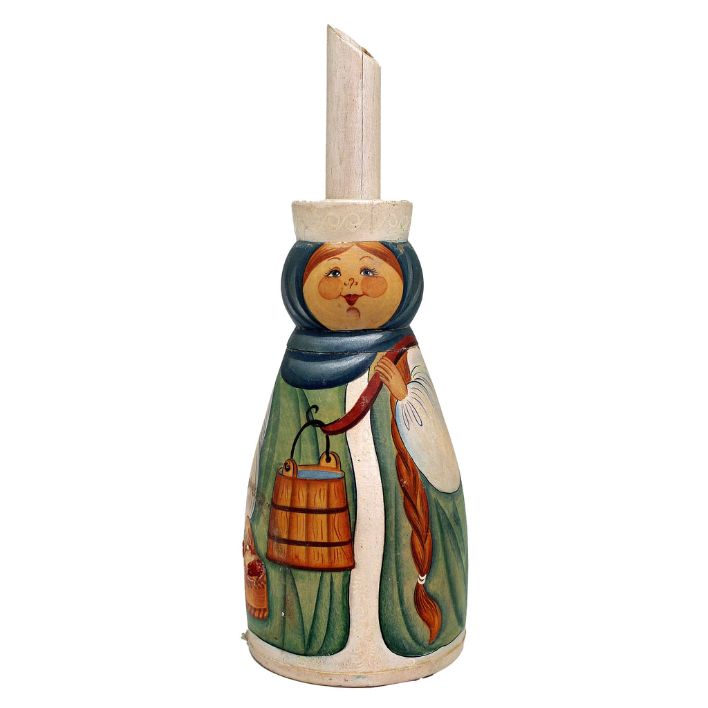 A wooden figurine depicting a woman with a basket, wearing a green dress and a blue headscarf.