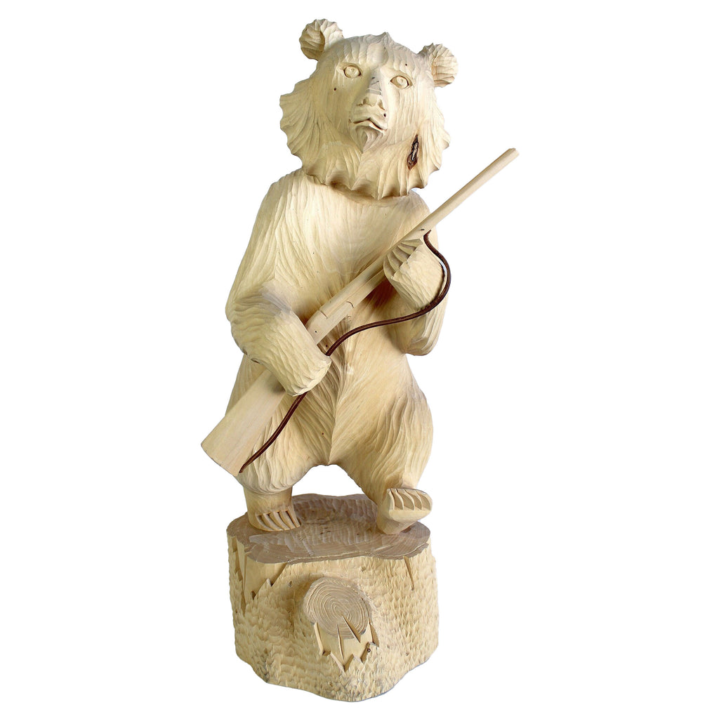 A wooden carving of a bear holding a rifle.