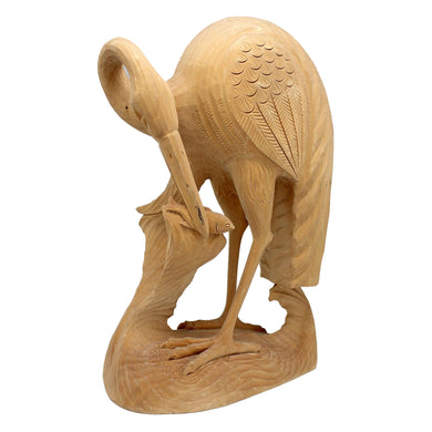 A wooden sculpture of a bird, possibly a crane, with intricate carvings and details.