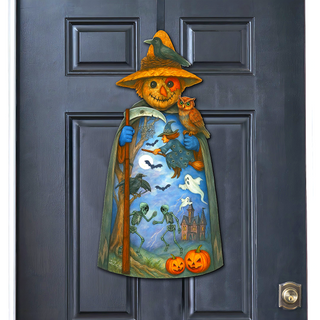 A Halloween-themed door decoration featuring a scarecrow figure with a hat, holding a scythe and a bird, and a castle, jack-o-lanterns, and skeleton figures.
