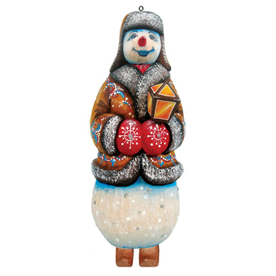 A colorful snowman ornament with a red nose, wearing a brown coat and holding a red and yellow lantern.
