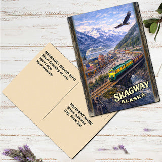 A postcard featuring a scenic mountain landscape with a train passing over a bridge, and the word 'Skagway' prominently displayed.