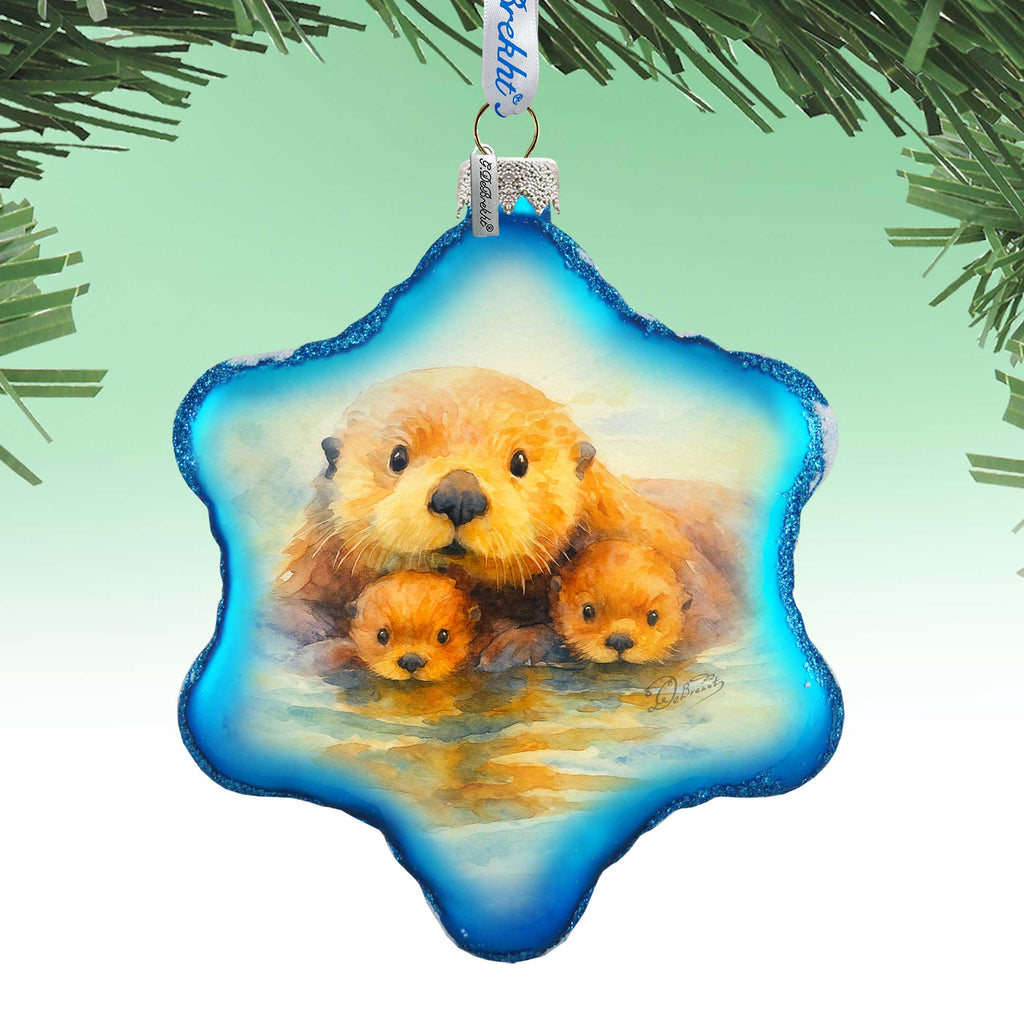 A blue star-shaped ornament with a painting of three otters swimming in a body of water.