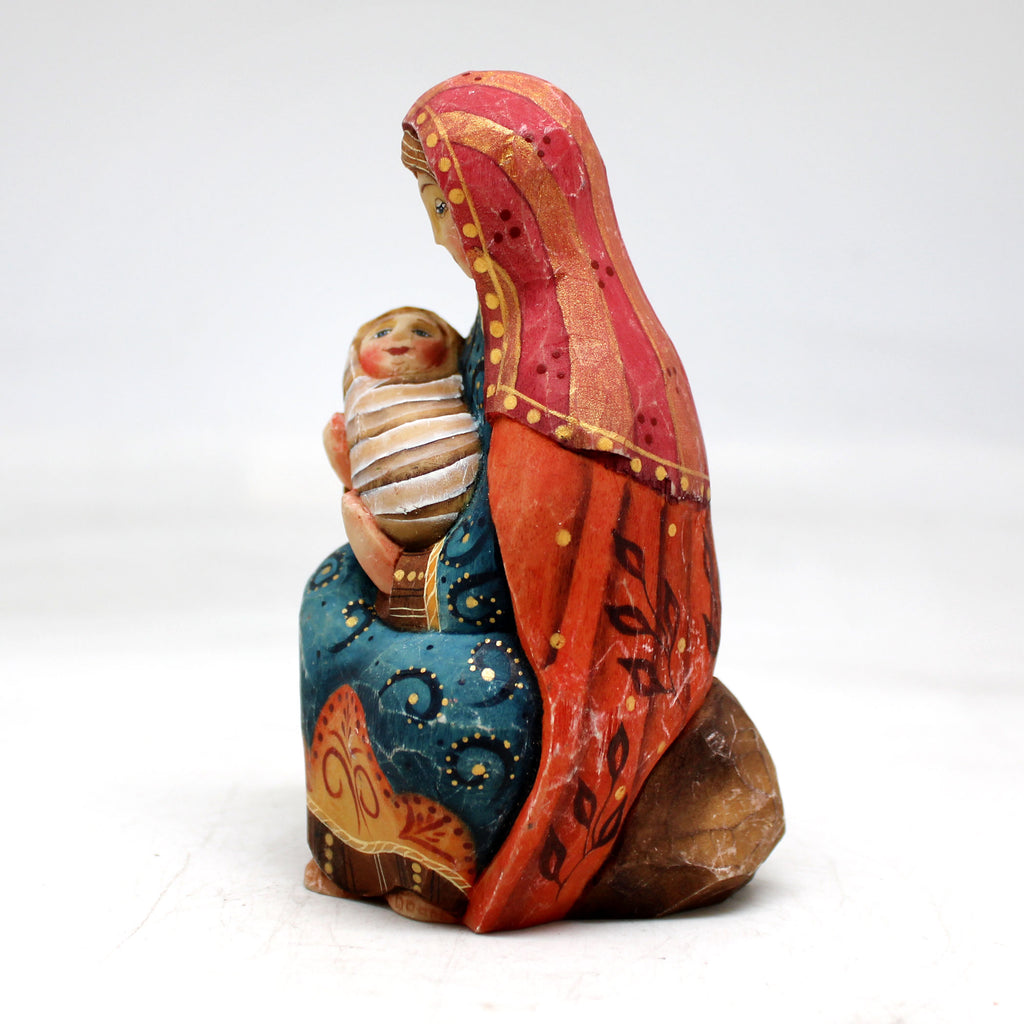 a ceramic figurine of a woman holding a baby
