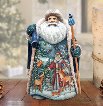 A detailed figurine of Santa Claus, adorned with a blue and white coat, holding a blue staff, and surrounded by various animals such as deer, foxes, and birds, all set against a snowy winter landscape.