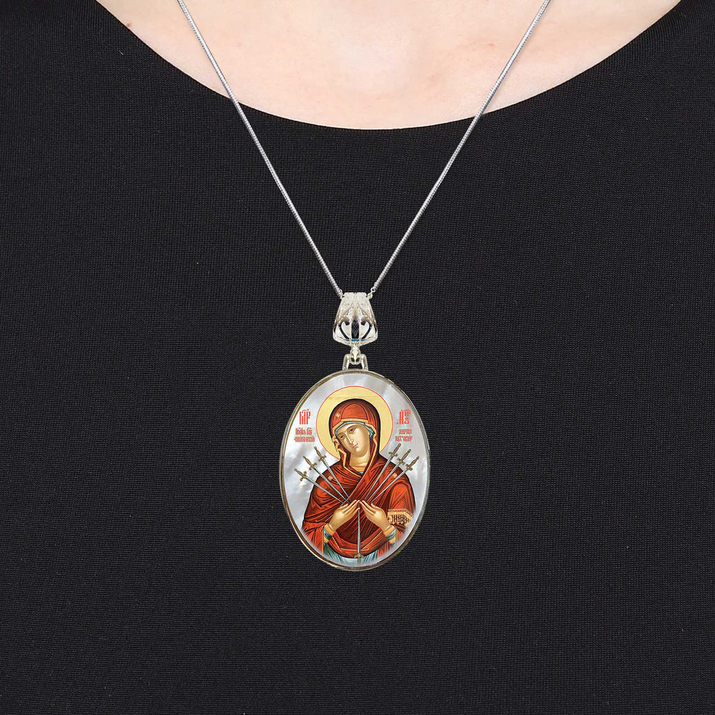 A silver necklace with a circular pendant featuring an image of a religious figure.