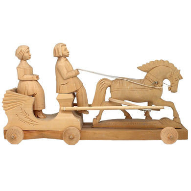 A wooden toy horse and carriage with two carved figures, one seated and one standing, on a wooden platform.