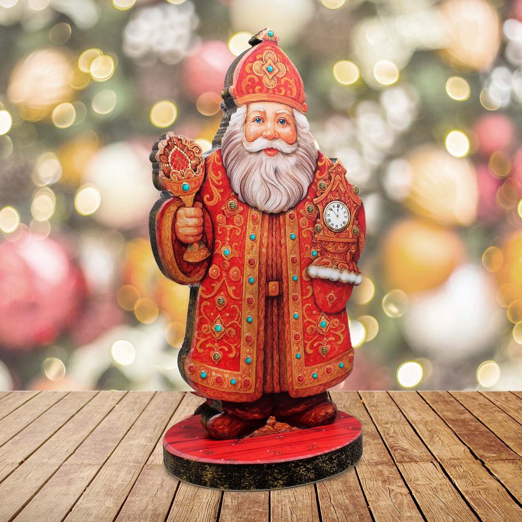 A wooden Santa Claus figurine holding a candelabra stands on a wooden surface against a blurred background of Christmas ornaments.