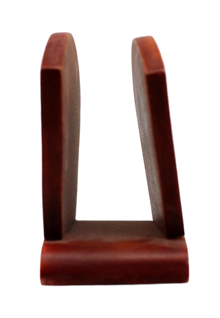 A red wooden object with a curved shape, standing upright against a black background.