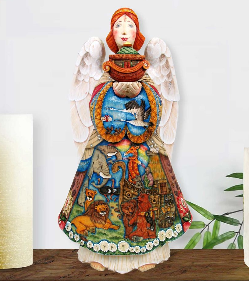 A colorful, hand-painted angel figurine with wings and a basket, standing on a wooden surface.