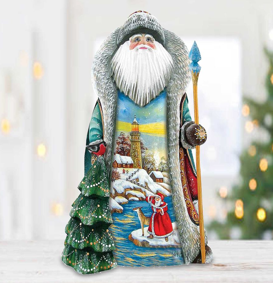 A colorful and detailed figurine of Santa Claus, with a snowy landscape and Christmas trees in the background, is displayed on a wooden surface.