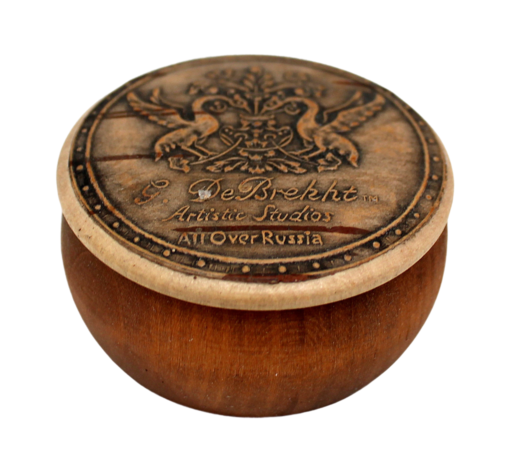 A wooden bowl with a decorative lid featuring a crest and text.