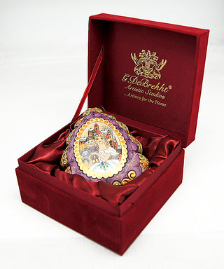A red box containing a decorative ornament with a purple and gold design, placed on a white surface.