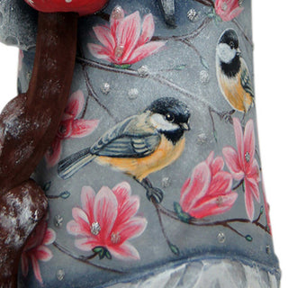 a close-up of a decorative item with a floral pattern, including pink flowers and two small birds.