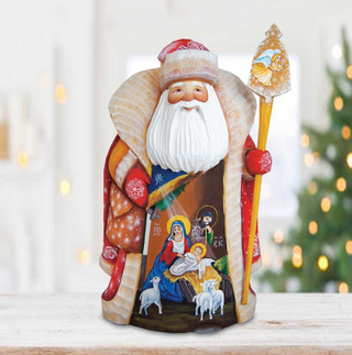 A figurine of Santa Claus holding a nativity scene, with a background of Christmas lights.