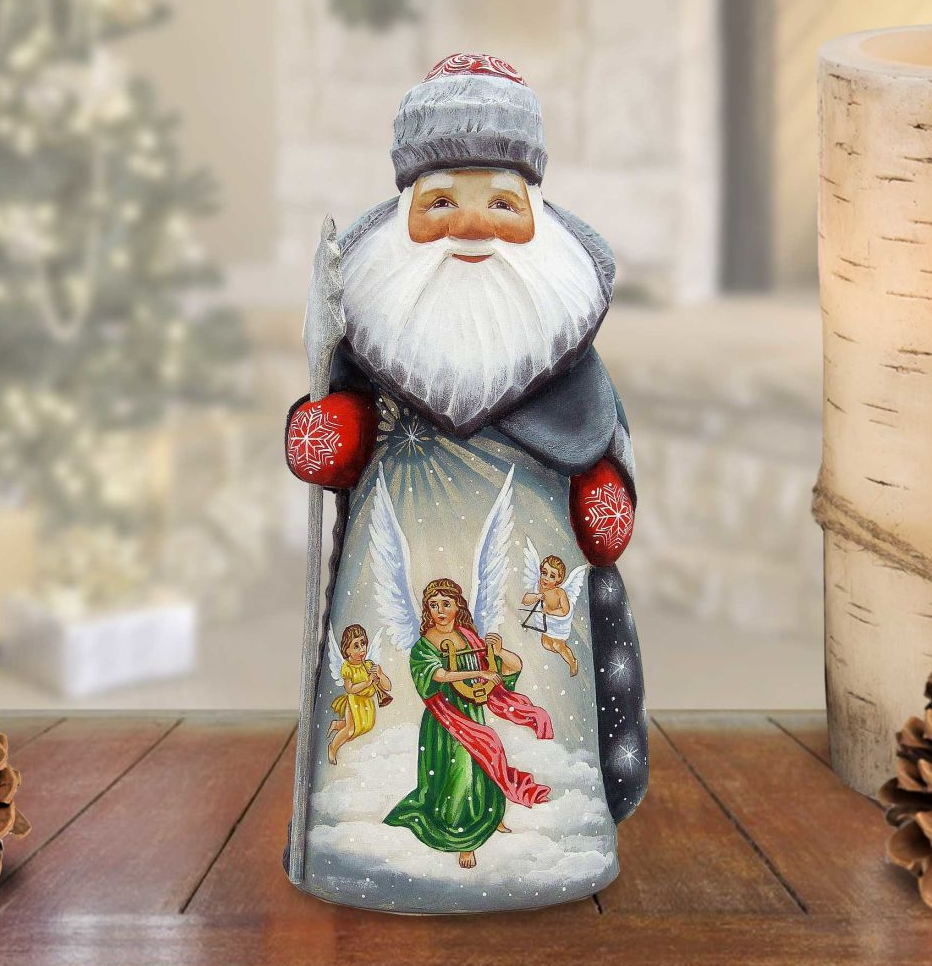 A hand-painted Christmas ornament depicting Santa Claus with angels, set against a snowy background.