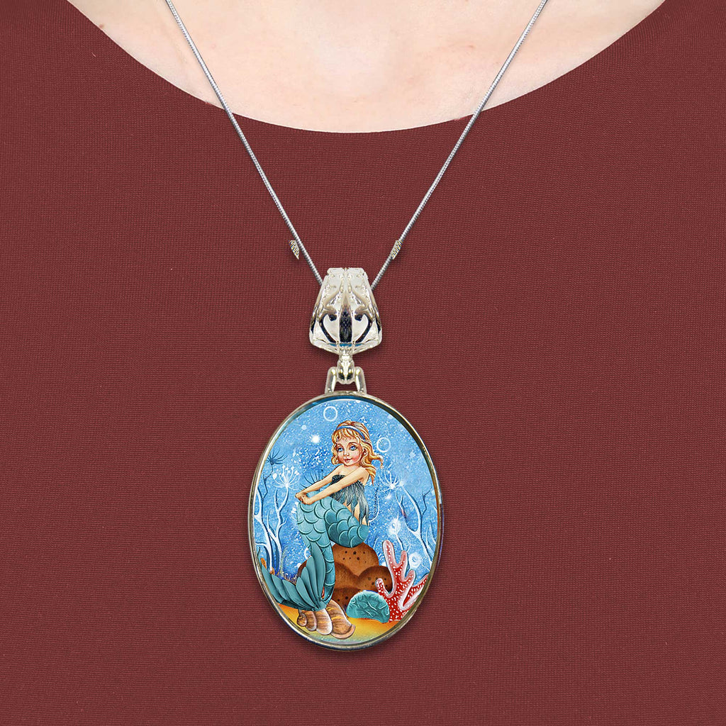 A necklace with a pendant featuring a mermaid image.