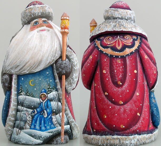 two intricately painted figurines of Santa Claus, one in red and the other in blue, both adorned with snow and a white rabbit. Santa Claus is holding a staff, and the background depicts a snowy landscape with a crescent moon and stars.