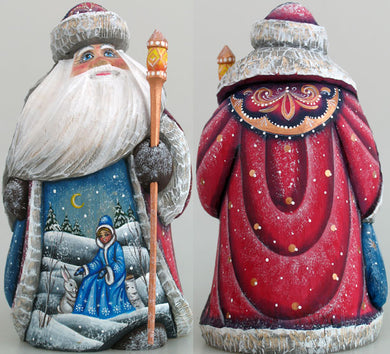 two intricately painted figurines of Santa Claus, one in red and the other in blue, both adorned with snow and a white rabbit. Santa Claus is holding a staff, and the background depicts a snowy landscape with a crescent moon and stars.