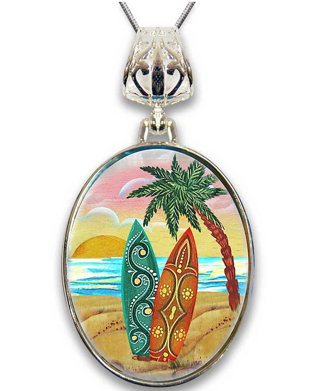 A round pendant with a painting of two surfboards and a palm tree on a beach scene.