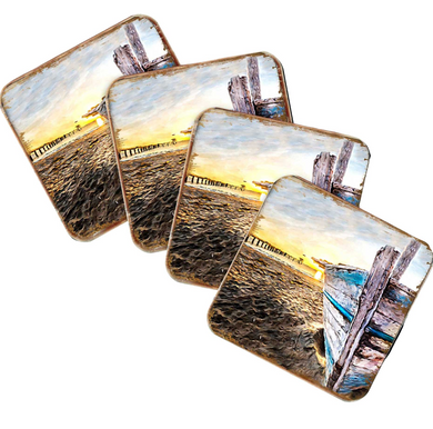 a collection of four square coasters, each featuring a different beach scene. The coasters display various beach elements, such as a pier, a boat, and a sunset.