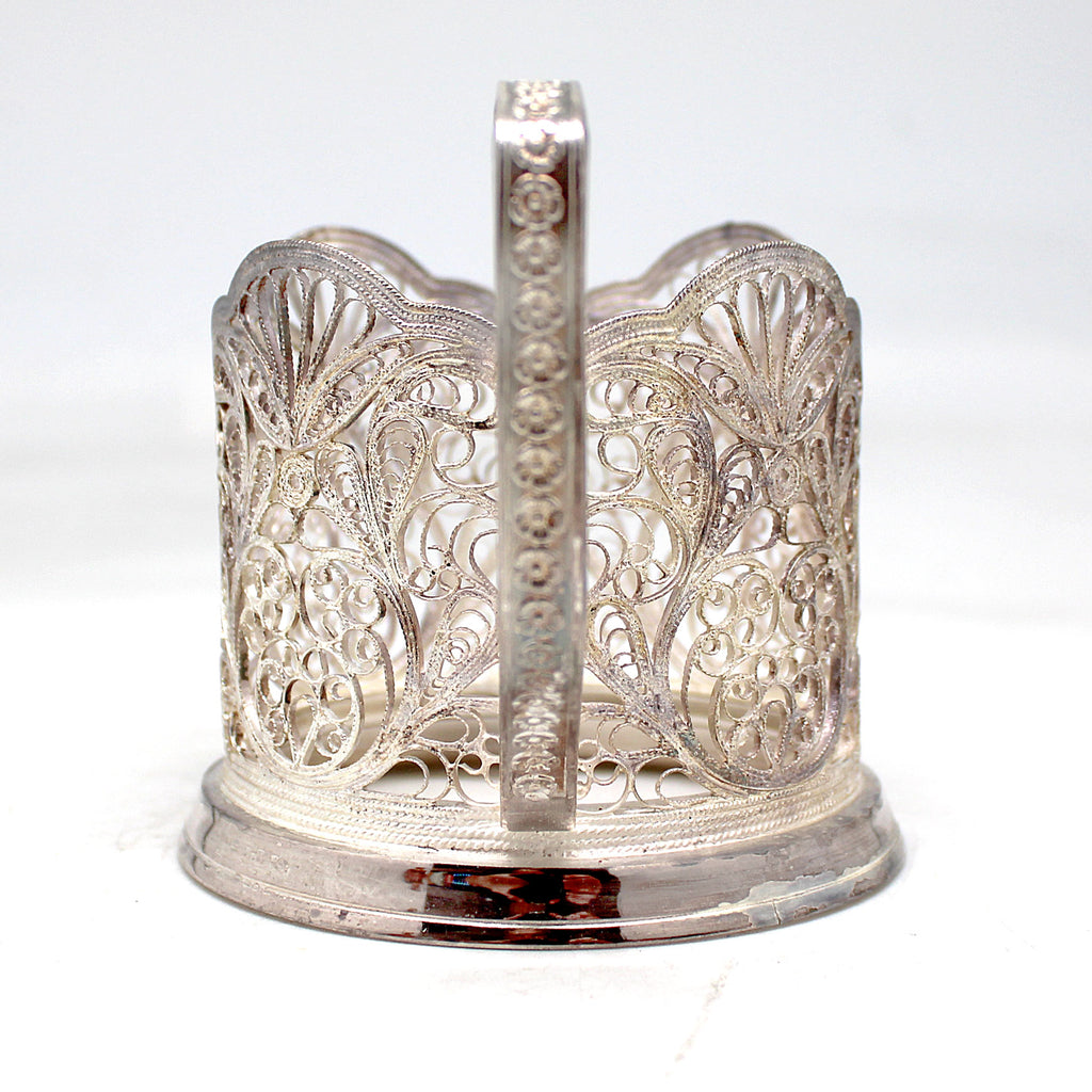 a silver candle holder with a candle inside of it