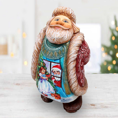 a ceramic figurine of a santa clause holding a christmas tree