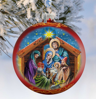 A red and gold ornament depicting the Holy Family in a nativity scene, with the baby Jesus surrounded by the Magi and the Wise Men.