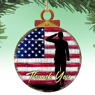 A Christmas ornament with a silhouette of a person saluting in front of an American flag.