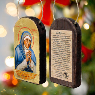 two wooden ornaments, each depicting a religious figure, likely a saint or religious icon. The ornaments are hanging from a string, and there is a label attached to one of them providing information about the ornament.