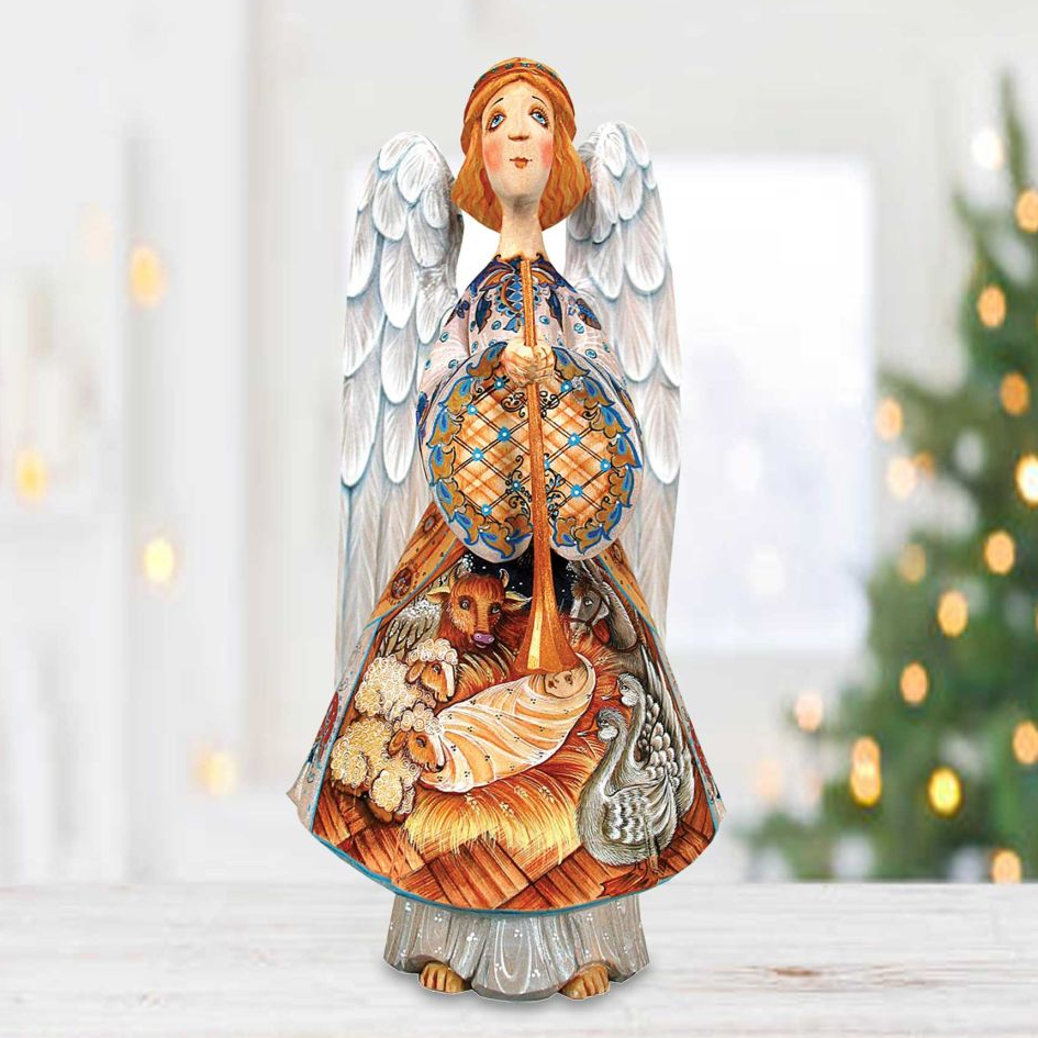 A figurine of an angel holding a musical instrument, with a detailed and colorful design, stands on a wooden surface against a blurred background of a Christmas tree.