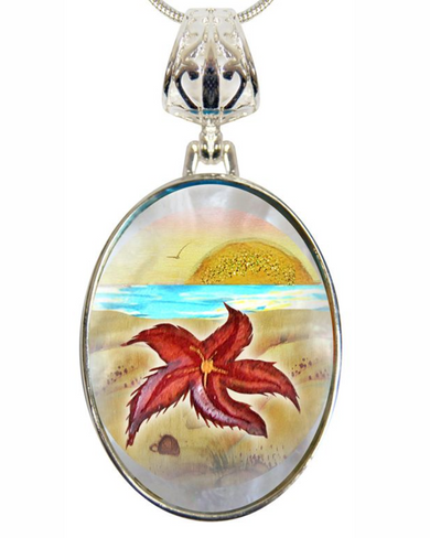 A pendant necklace with a circular design featuring a red flower and a sunset landscape.