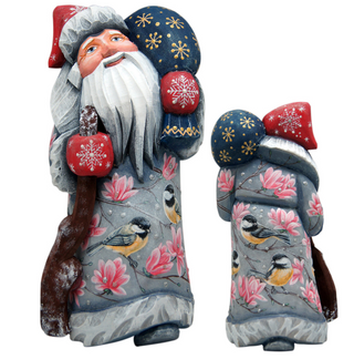 two wooden Santa Claus figurines, each adorned with a unique pattern of snowflakes and birds. The Santa Claus on the left is larger and taller, while the one on the right is smaller and shorter. Both figurines are intricately detailed, showcasing the craftsmanship involved in their creation.